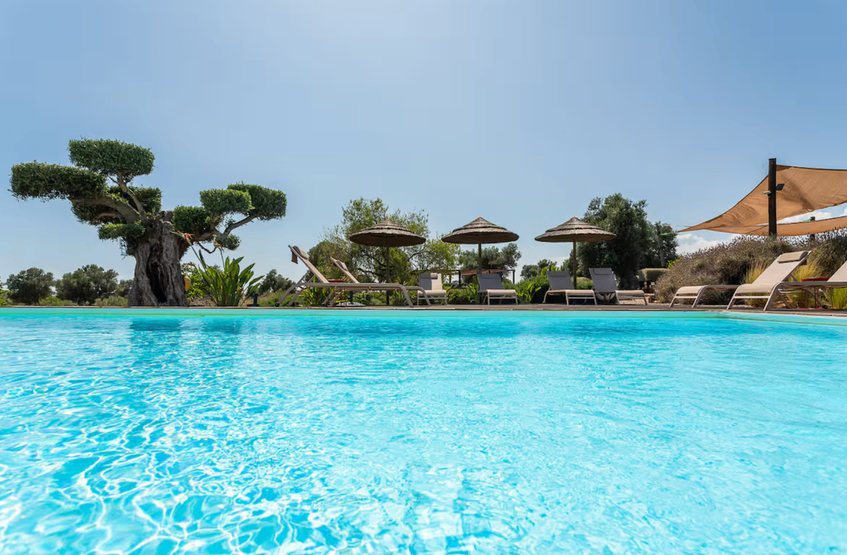 Turquoise pool at the Algarve retreat villa under a clear blue sky