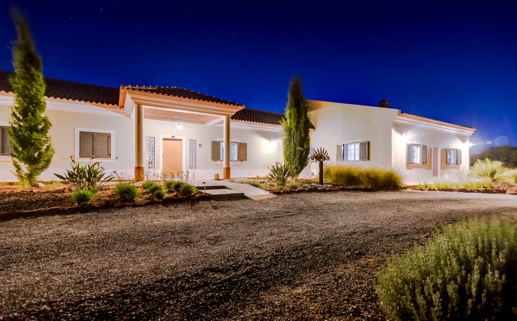 The villa illuminated at night beneath the stars