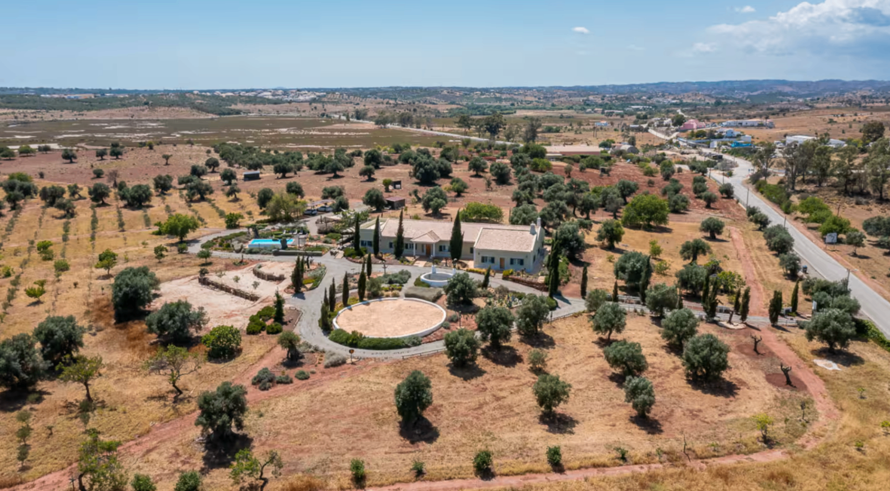 Daytime aerial view of the retreat villa and surrounding olive landscape